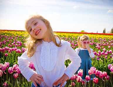 Children standing in a field of flowers