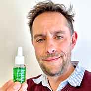 Picture of Sam Cremnitz holding a bottle of Emotional Body Essence