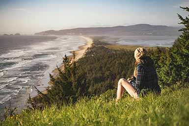Picture of a person sitting in nature by the coast thinking