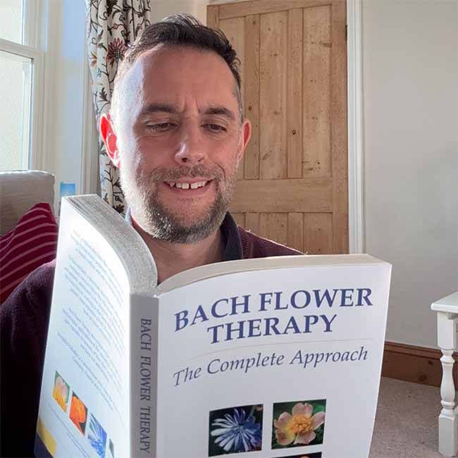 Sam Cremnitz reading the book Bach Flower Therapy by Mechthild Schaeffer