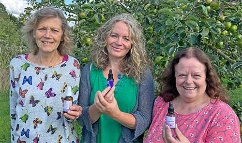 Picture of three people holding bottles of Crystal Herbs flower essences