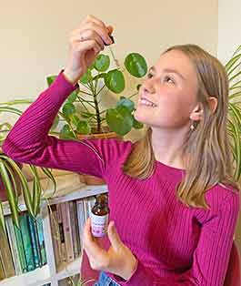 How to use a flower essence - person taking a flower essence using a dropper bottle