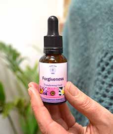 Forgiveness Essence bottle held in a hand