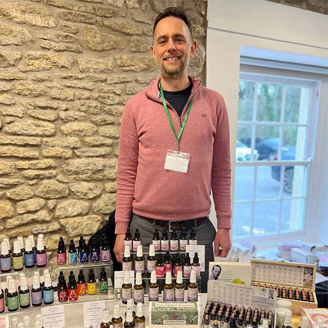 A picture of Sam Cremnitz with the Crystal Herbs stand at the 2026 BFVEA Gathering