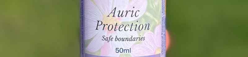 A bottle of Auric Protection Essece spray with a green background