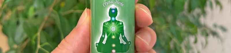 A bottle of Heart Chakra Essence with a plant in the background